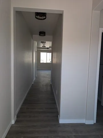 a view of a hallway with wooden floor and closet