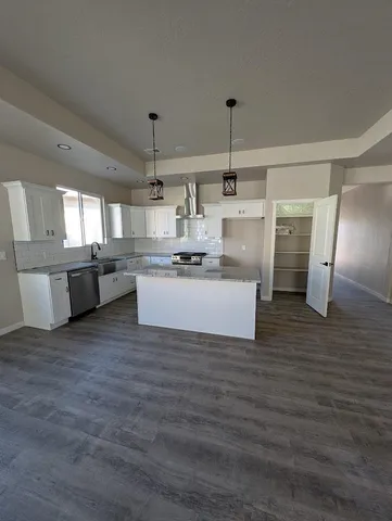 a kitchen with a refrigerator and white cabinets