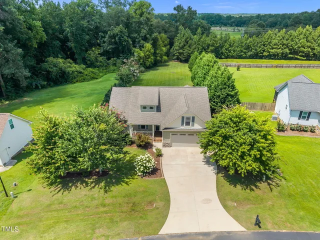an aerial view of a house with garden space and a lake view