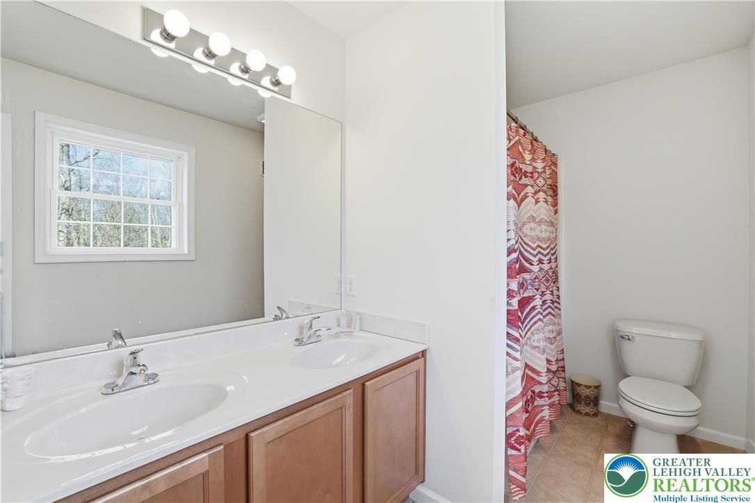 112 Amos Circle Bushkill, PA 18324 - Photo 23 of 52 a bathroom with a granite countertop sink a toilet and a mirror