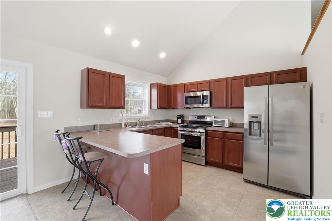 112 Amos Circle Bushkill, PA 18324 - Photo 9 of 52 a kitchen with stainless steel appliances granite countertop a stove a sink a refrigerator and a microwave