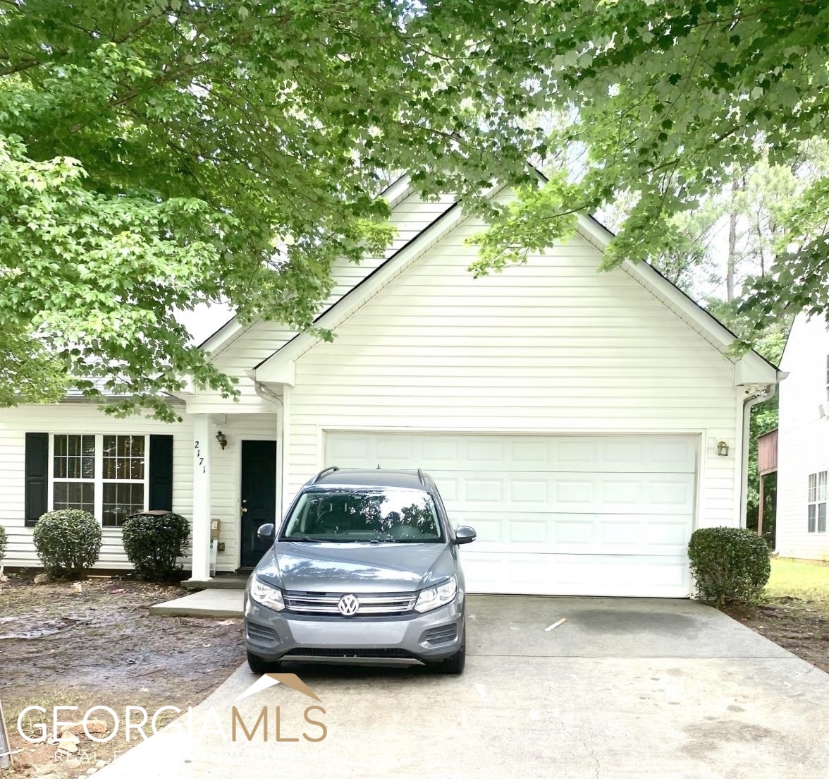 a car parked in front of white house