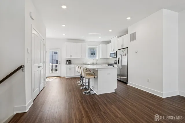 a kitchen with white cabinets and stainless steel appliances