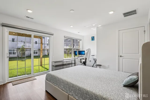 a bedroom with a large bed and wooden floor