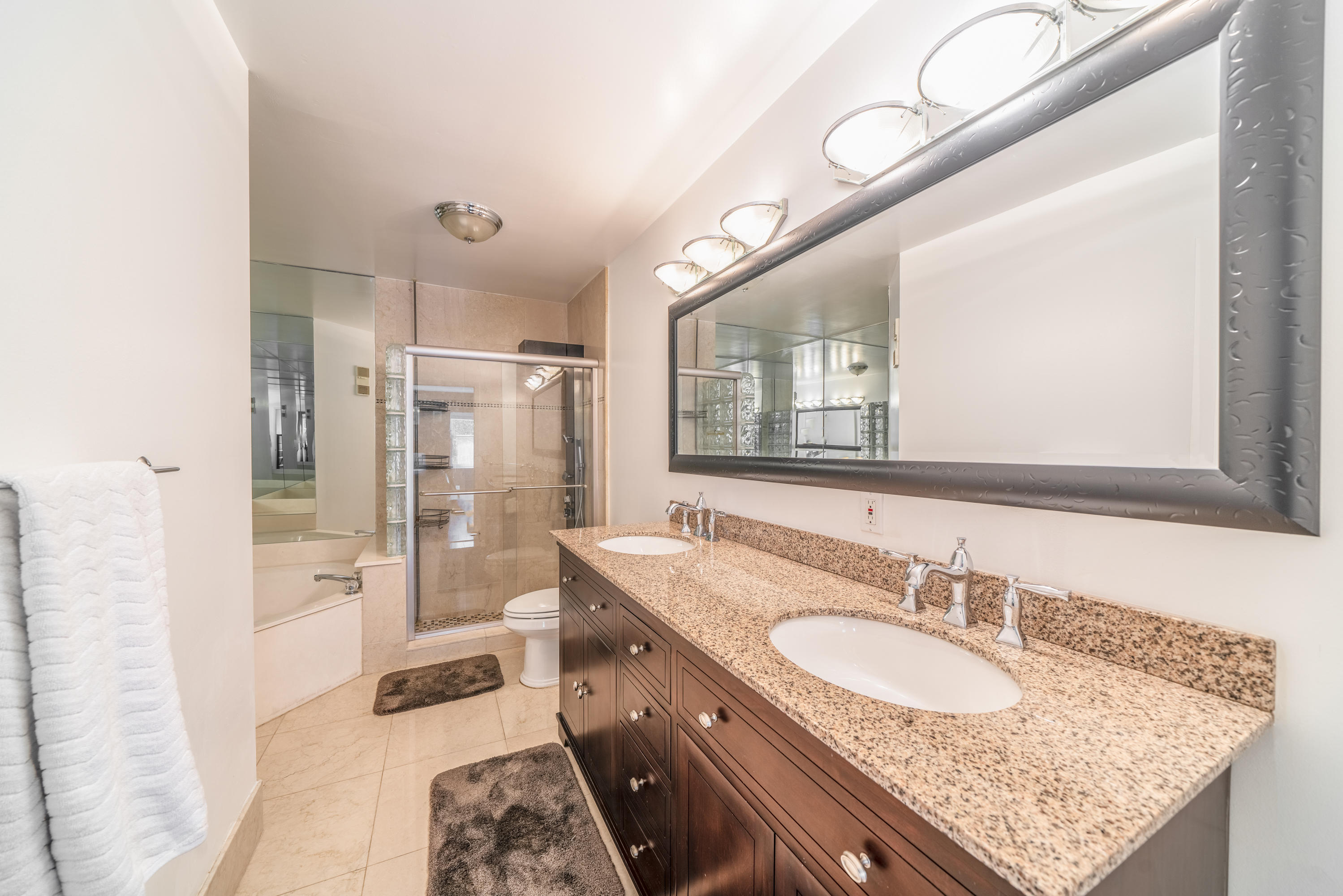 10399 Lake Vista Circle Boca Raton, FL 33498 - Photo 9 of 18 a bathroom with a granite countertop double vanity sink mirror and shower