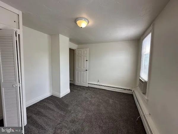an empty room with windows and closet