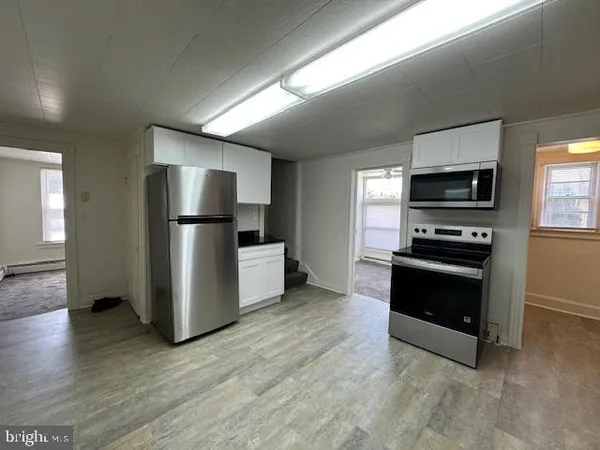 a kitchen with a refrigerator and a stove top oven