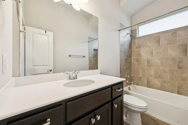 a bathroom with a sink a toilet a mirror a bathtub and shower