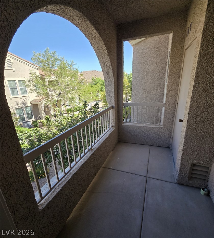 10550 West Alexander Road, Unit 2183 Las Vegas, NV 89129 - Photo 5 of 22 An inviting balcony space with archways offers views of lush green surroundings and neighborhood homes.