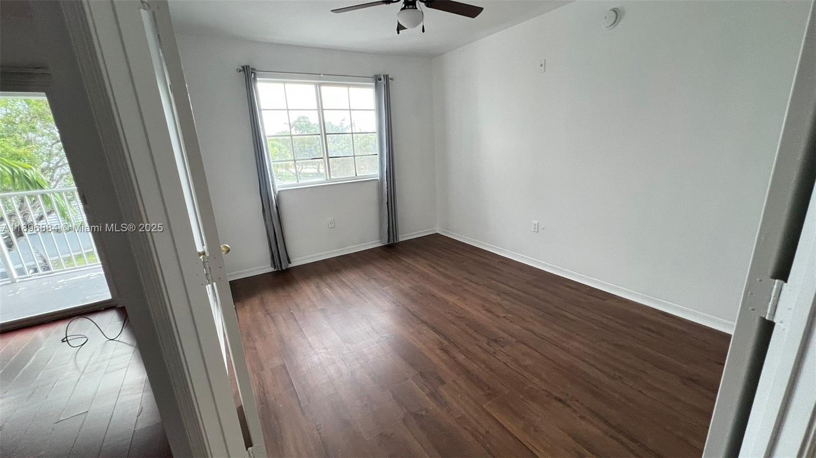 711 Southwest 111th Way, Unit 301 Pembroke Pines, FL 33025 - Photo 11 of 20 a view of an empty room with wooden floor and a window