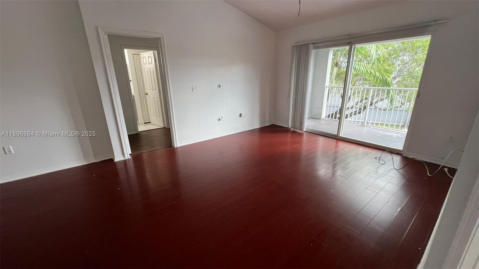 711 Southwest 111th Way, Unit 301 Pembroke Pines, FL 33025 - Photo 5 of 20 an empty room with wooden floor and windows