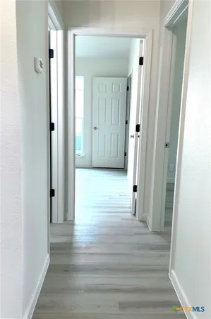a view of a hallway with wooden floor