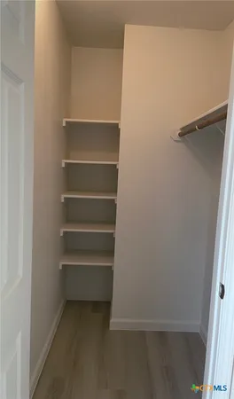 a view of walk in closet with empty racks