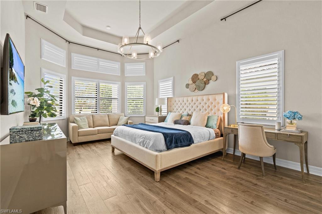 4644 Azalea Drive Naples, FL 34119 - Photo 15 of 48 a bedroom with a bed and a chandelier