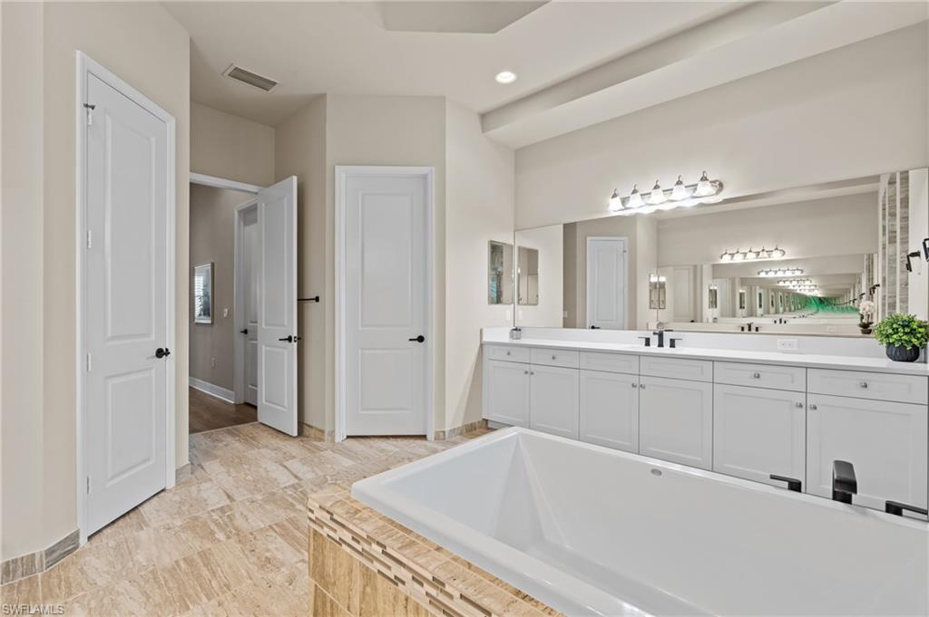 4644 Azalea Drive Naples, FL 34119 - Photo 18 of 48 a spacious bathroom with a tub sink and mirror