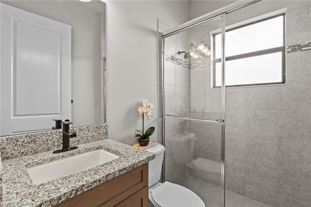 4644 Azalea Drive Naples, FL 34119 - Photo 20 of 48 a bathroom with a granite countertop sink toilet and shower