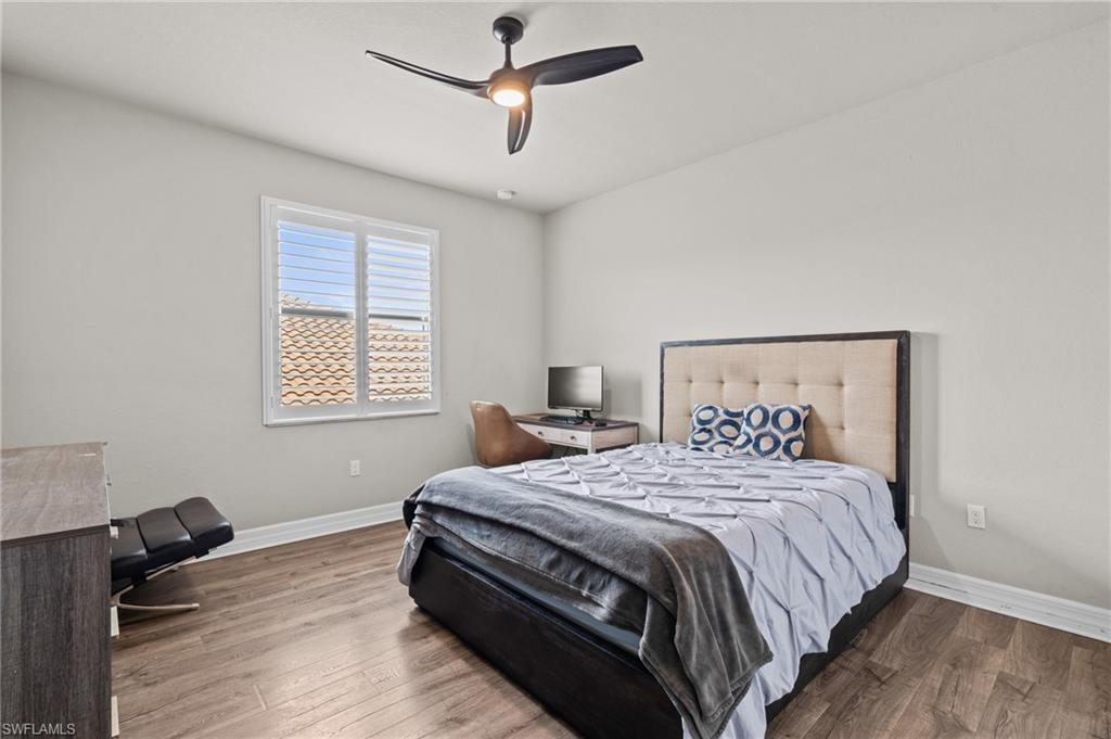 4644 Azalea Drive Naples, FL 34119 - Photo 29 of 48 a bedroom with a bed and wooden floor