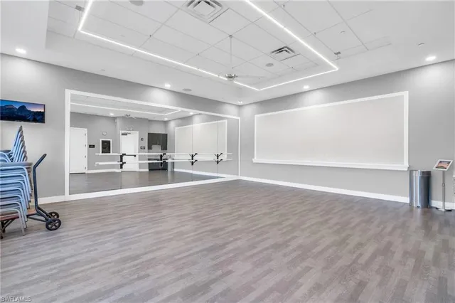a view of a room with gym equipment and mirrors