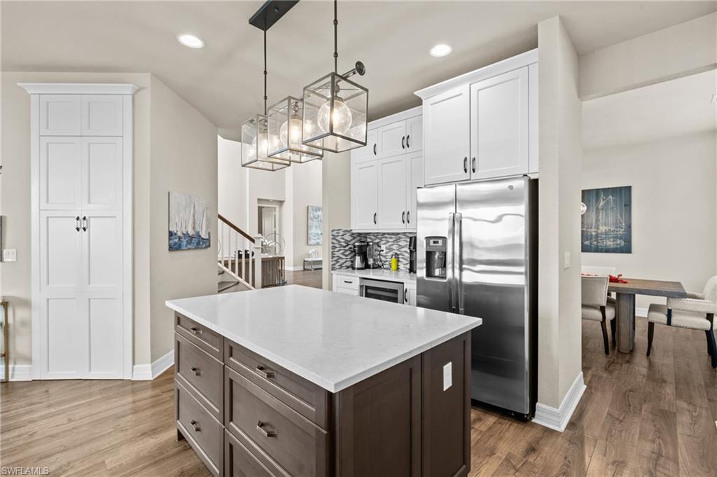 4644 Azalea Drive Naples, FL 34119 - Photo 9 of 48 a kitchen with kitchen island white cabinets and stainless steel appliances
