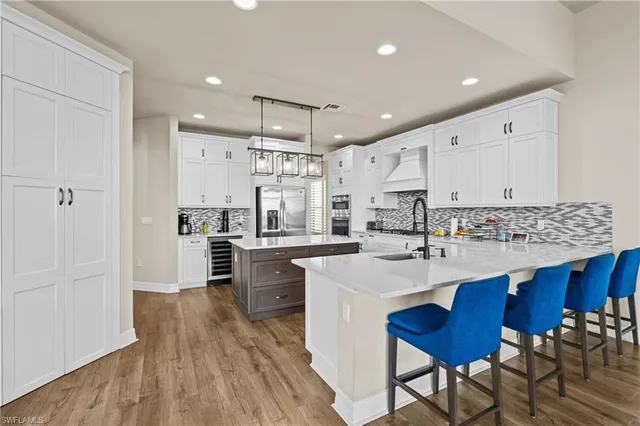 a kitchen with stainless steel appliances sink refrigerator dining table and chairs