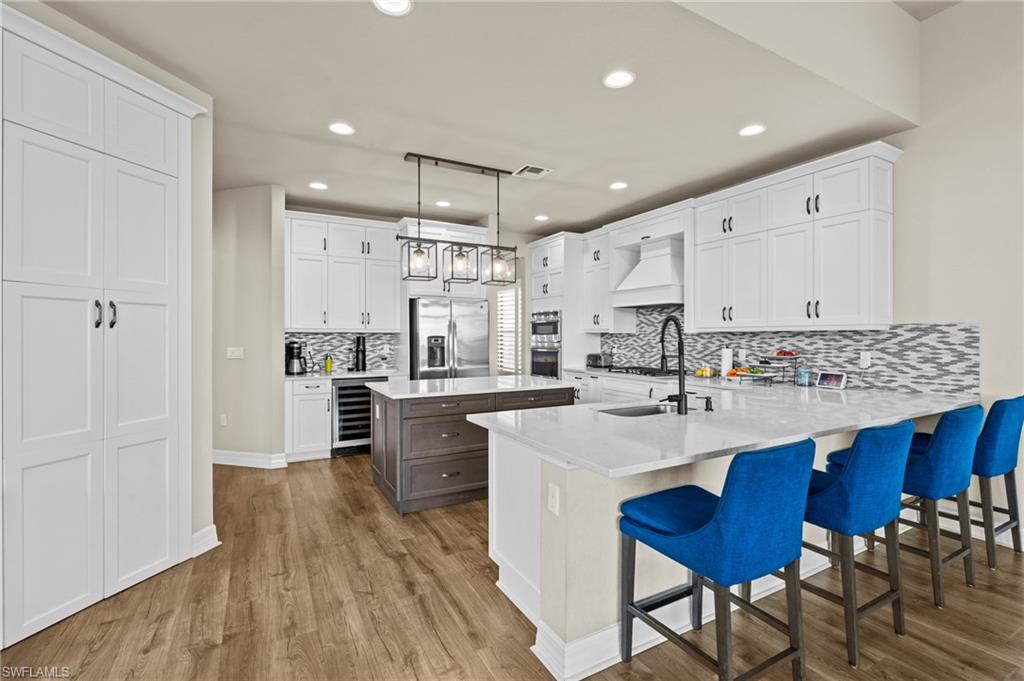 4644 Azalea Drive Naples, FL 34119 - Photo 10 of 48 a kitchen with stainless steel appliances sink refrigerator dining table and chairs