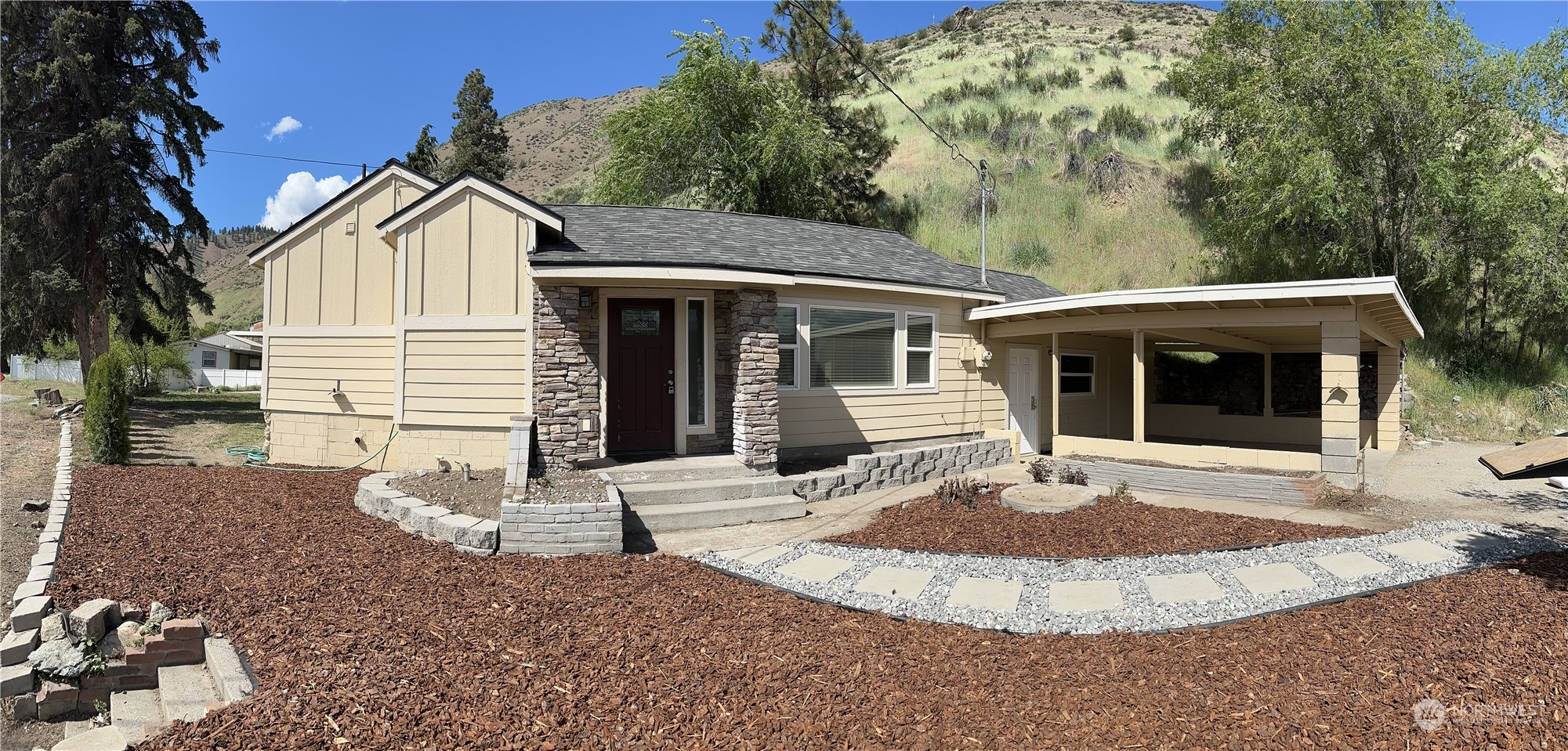 a view of a white house with a small yard and large tree