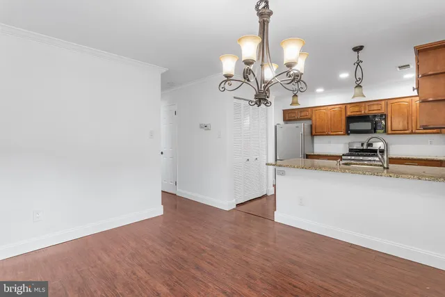 a view of kitchen with sink microwave and cabinets