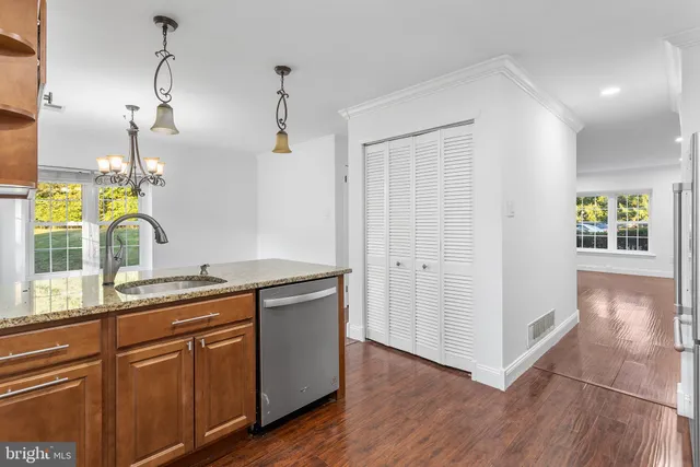 a kitchen with a sink cabinets and wooden floor