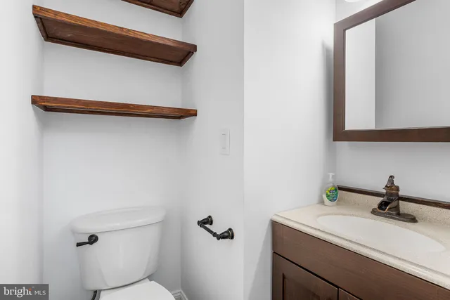a bathroom with a sink a toilet and mirror
