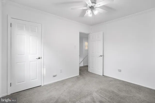 a view of an empty room and chandelier fan