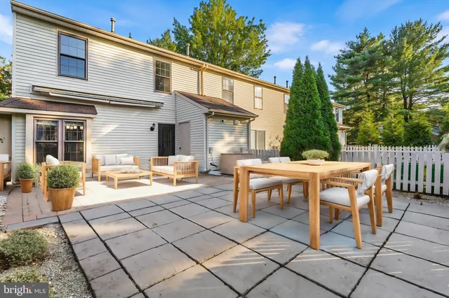 a view of a patio with table and chairs with wooden fence and plants