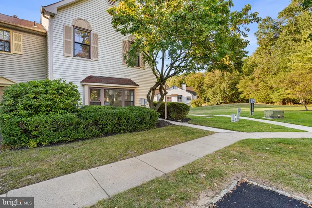 a view of a house with a big yard and large trees