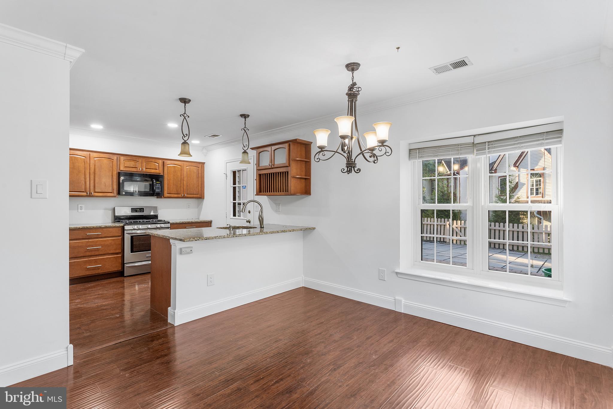 16 Carlyle Court Robbinsville, NJ 08691 - Photo 10 of 30 a kitchen with stainless steel appliances kitchen island granite countertop a stove a sink dishwasher a refrigerator and a dining table with wooden floor