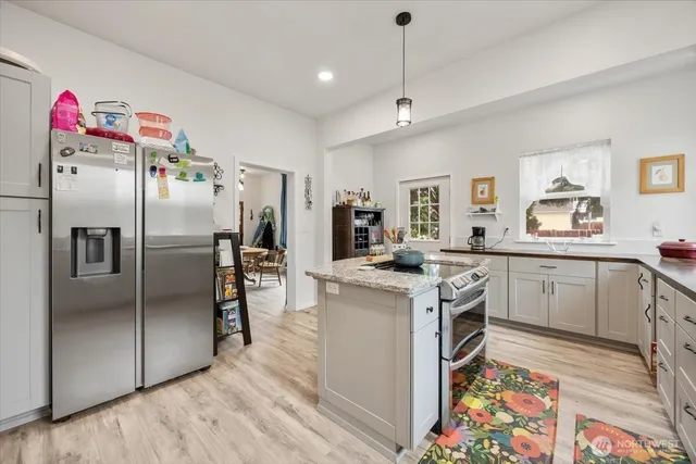 a kitchen with granite countertop stainless steel appliances a refrigerator and a sink