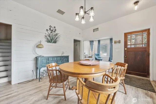 a dining room with furniture a chandelier and wooden floor