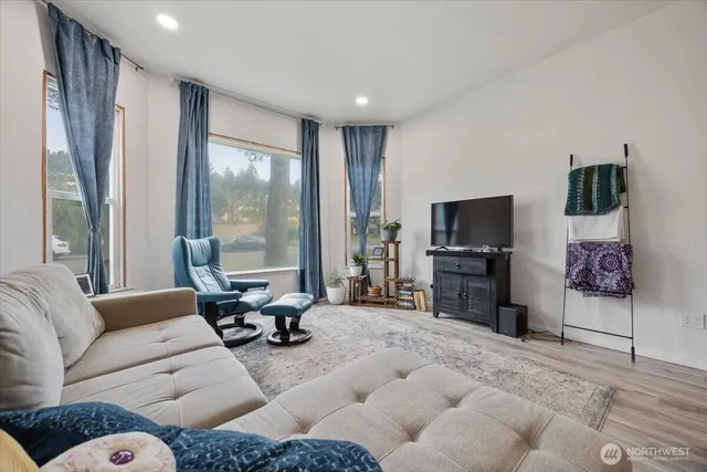 a living room with furniture a large window and a flat screen tv