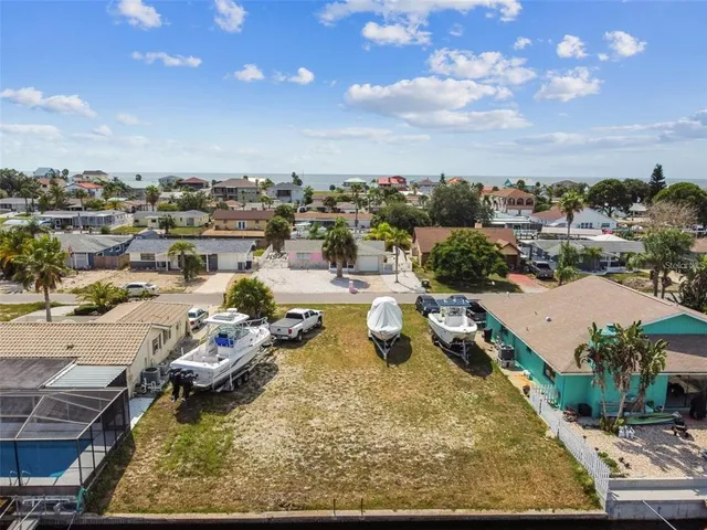 an aerial view of a swimming pool with lawn chairs and iron fence