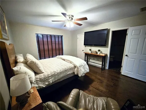 a bedroom with a bed a couch and a flat screen tv