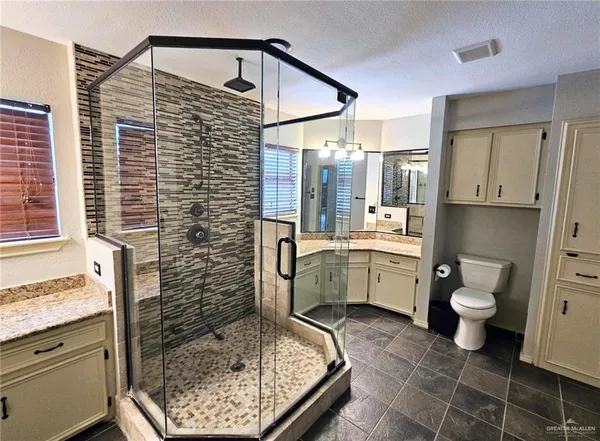 a bathroom with a granite countertop sink toilet and shower