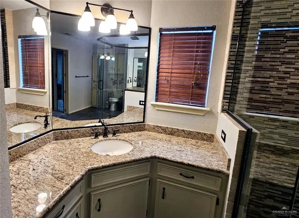 a bathroom with a granite countertop sink and a mirror