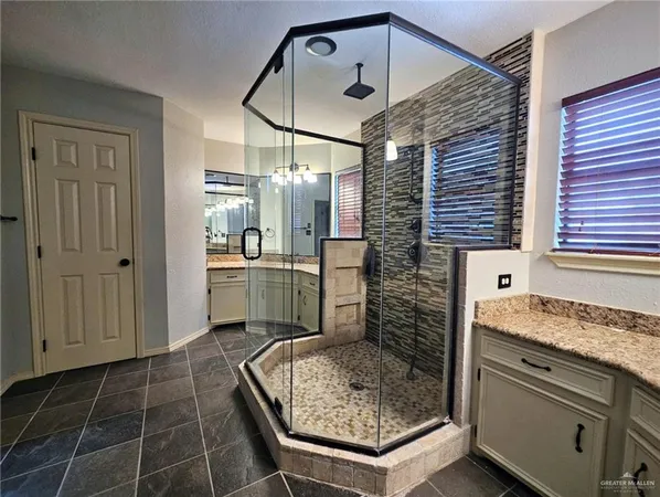 a bathroom with a granite countertop sink a toilet and shower