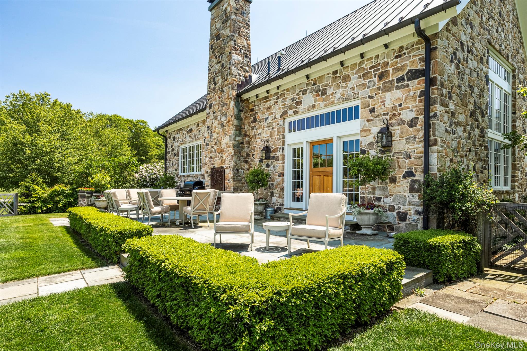 147 Moadock Road Millerton, NY 12546 - Photo 4 of 48 a view of a patio with couches table and chairs with plants and garden
