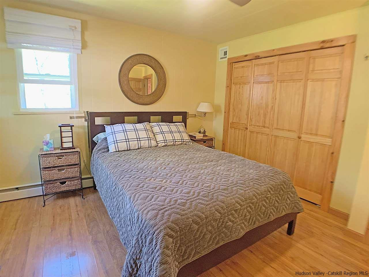 56 Bellwood Road Saugerties, NY 12477 - Photo 14 of 35 a bedroom with a bed and a closet with wooden floor