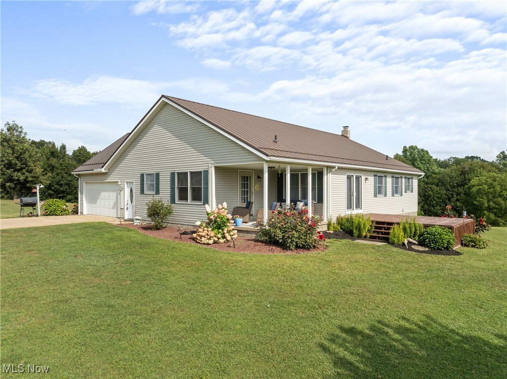 40885 Mt Hope Road Flushing, OH 43977 - Photo 32 of 50 View of front of house with a metal roof, driveway, a front lawn, a garage, and a chimney
