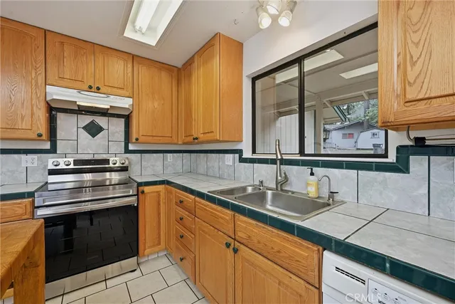 a kitchen with stainless steel appliances granite countertop a sink stove and cabinets