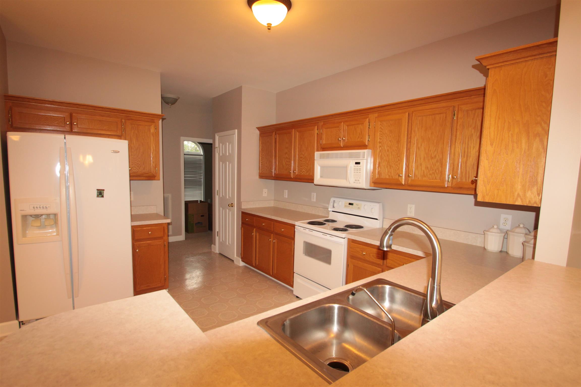 1013 Woods Ferry Road Lebanon, TN 37087 - Photo 10 of 20 a kitchen with stainless steel appliances granite countertop a sink and a refrigerator