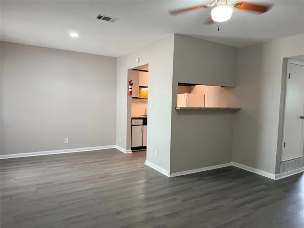 an empty room with wooden floor and cabinet