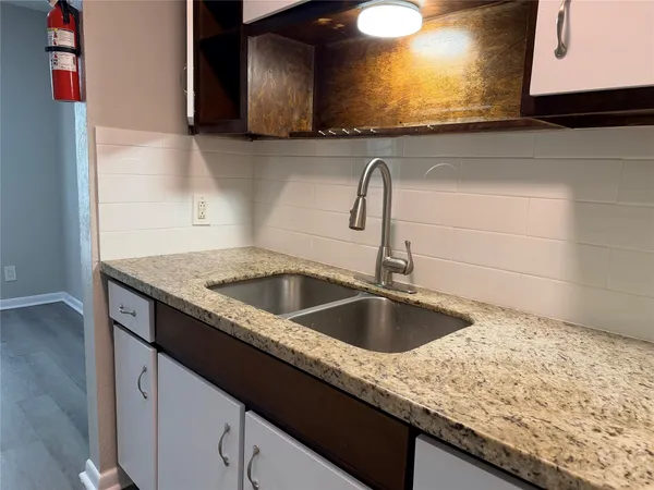 a kitchen with granite countertop a sink and a stove