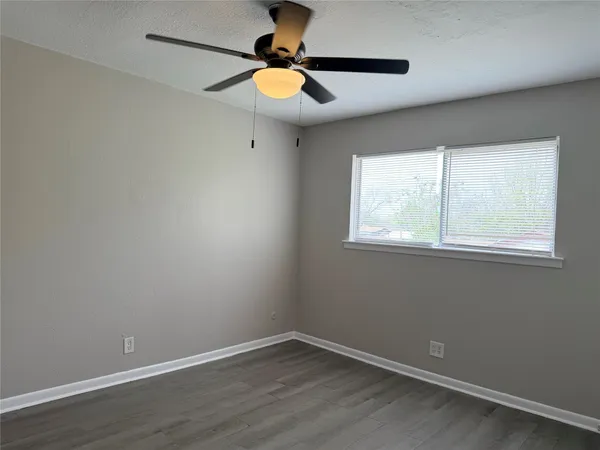 an empty room with a window and wooden floor