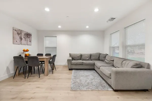a living room with furniture a dining table and a dining table with wooden floor